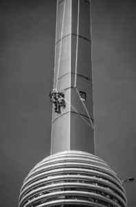 Ein Arbeiter klettert an der Spitze eines Wolkenkratzers