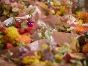 In braunes Papier eingewickelte bunte Blumensträuße