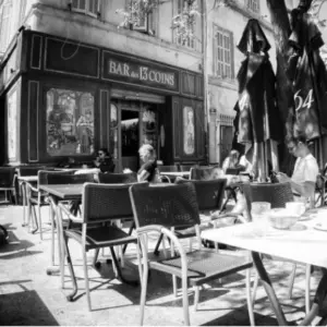 Café-Szene im Freien in Schwarz-Weiß, mit Menschen, die an Tischen