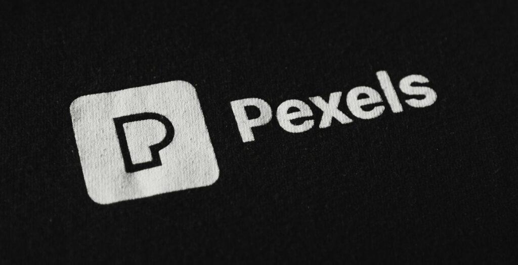 Close-up of the Pexels logo on a black background, perfect for branding needs.